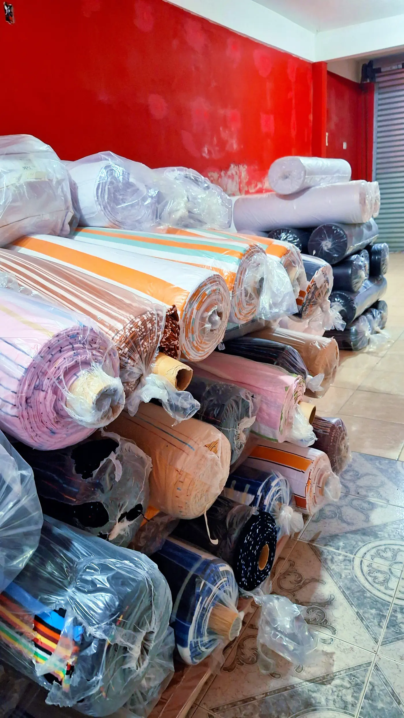 Rollos de tela apilados en el depósito de Indumentaria Flores Argentina.